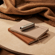 Ploom AURA front panels with Lunar Silver Augmented Pattern placed on top of a stack of notebooks.
