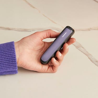 Əl Dəri ön panelli Ploom AURA cihazını tutur
