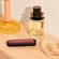 Ploom AURA front panel Dark Orchid accessory attached to device on a dressing table.