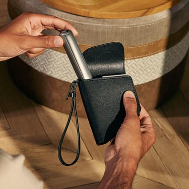 Əl Ploom AURA cihazını Ploom İkili Daşıma Qabı Jet Black aksesuarından çıxarır
