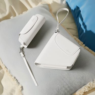 Ploom AURA White Glacier Solo and Duo Carry Case accessories on a cushion.