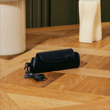 Masanın üzərində Ploom Aura Jet Black Solo daşıma qabı aksesuarı
