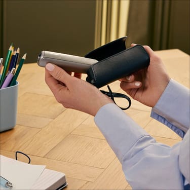 İstifadəçi Ploom AURA cihazını Solo Daşıma Qabı Jet Black aksesuarından çıxarır
