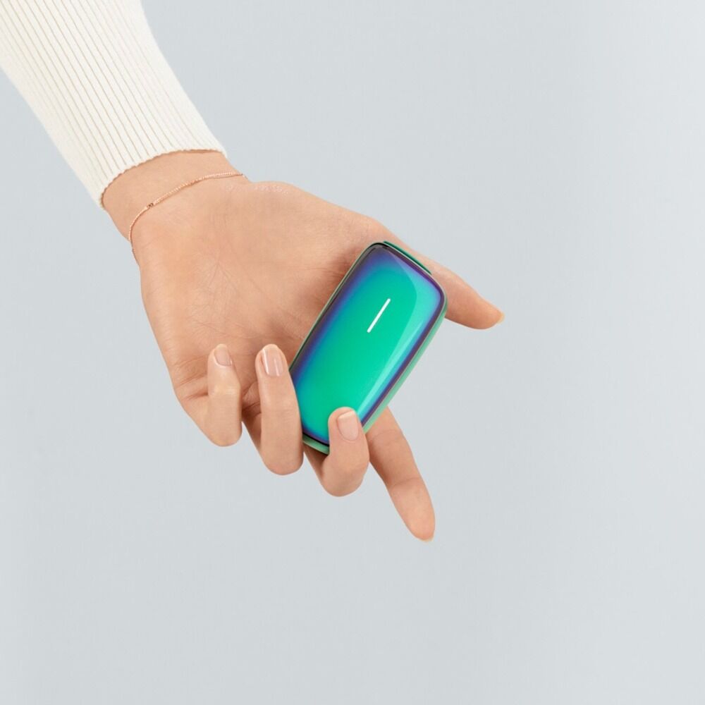 Ploom X Advanced Aqua Halo əlində tutulmuş halda, boz fon üzərində göstərilir