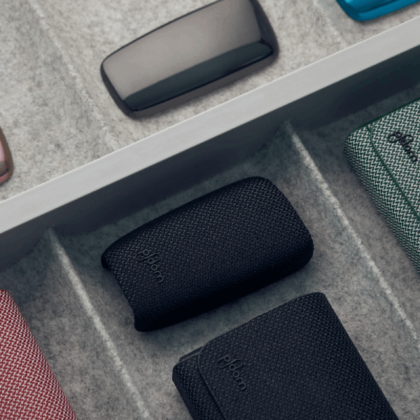 Ploom X Advanced fabric back cover black from the front side, shown in a drawer with other Ploom back covers and cases