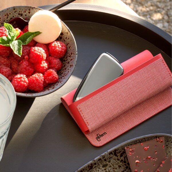 Ploom X Advanced Red carry case shown with Ploom device on a table, next to raspberries in a bowl and chocolate on a plate