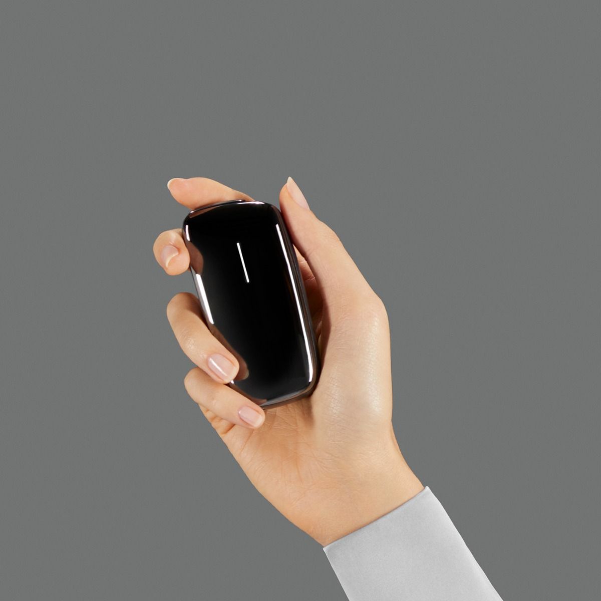 Ploom X Advanced Black shown in hand, against a grey background
